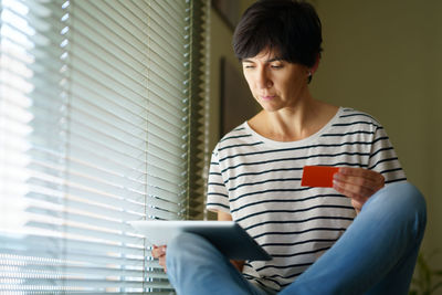 Woman shopping online while sitting at home