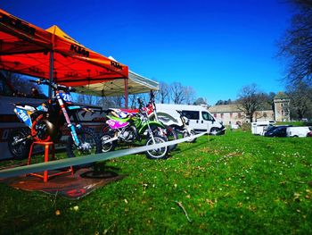 Bicycles on field against clear blue sky