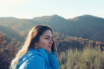 Portrait of beautiful woman against mountains