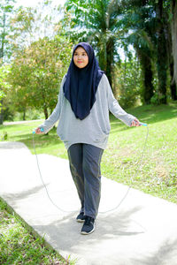 Portrait of young woman standing on field