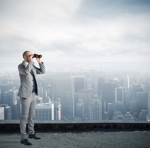 Man photographing with camera against sky