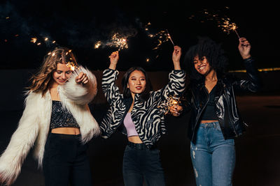 Group of young people looking at camera at night