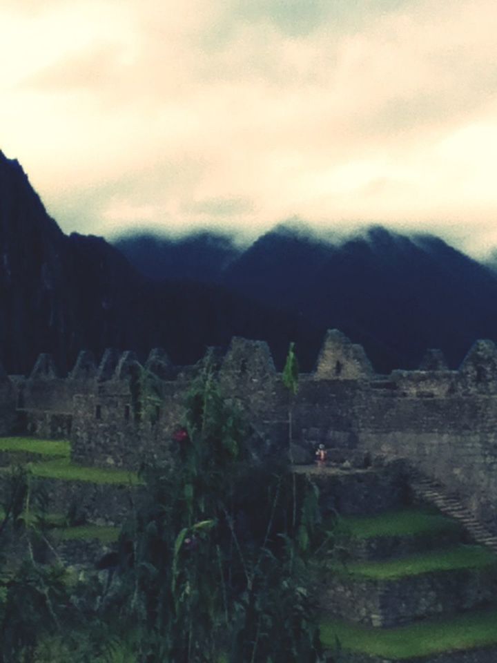 mountain, sky, cloud - sky, nature, tranquility, mountain range, landscape, beauty in nature, built structure, tranquil scene, grass, scenics, cloudy, plant, cloud, growth, architecture, animal themes, no people, outdoors