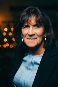 Close-up portrait of smiling senior woman at night