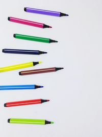 High angle view of colored pencils against white background