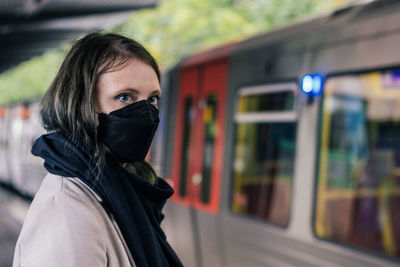 Portrait of young woman standing in city