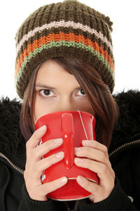 Portrait of young woman drinking glass in winter