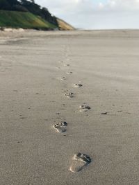 High angle view of footprints at beach against sky