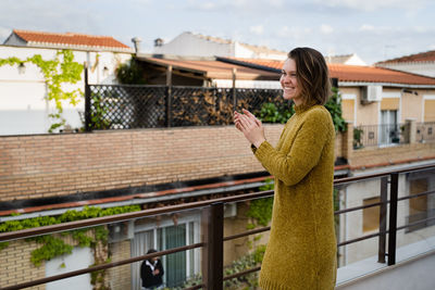 Side view of woman standing on balcony