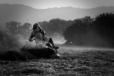 Man playing on field against mountain