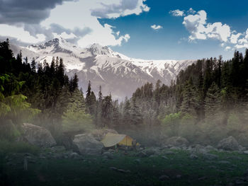 Scenic view of snowcapped mountains and camping tent against sky in india