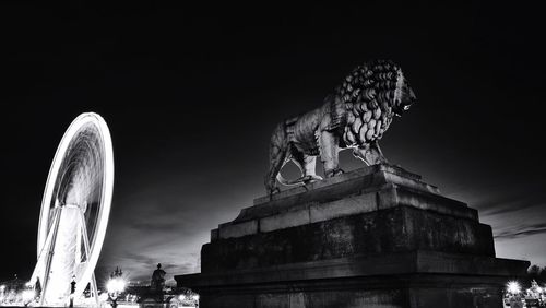 Lion statue with the big wheel light trial at place de la concorde against sky