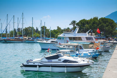 Sailboats moored at harbor against clear blue sky