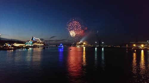 Firework display over river at night