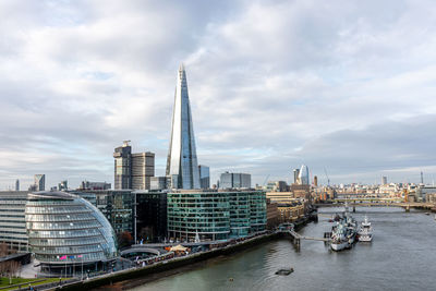 View of buildings at waterfront against cloudy sky