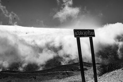 Information sign on road against sky