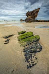 Scenic view of rocks on beach against sky