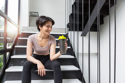 Side view of young woman exercising in gym