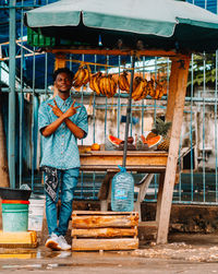 Portrait of smiling young man standing at a local fruit shot