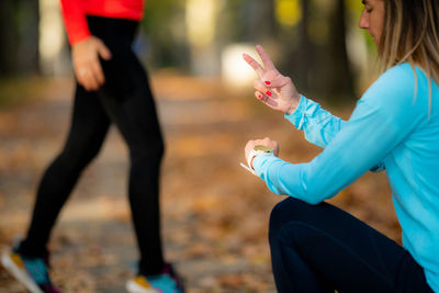 Woman exercising in public park with personal trainer in the fall. trainer counting jumps.