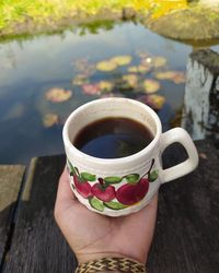 Cropped image of person holding coffee cup