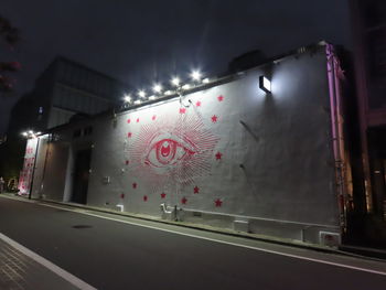 Illuminated lights on glass wall at night