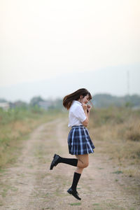 Rear view of woman standing on field