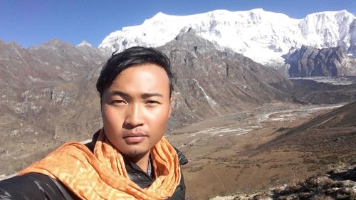 Portrait of young man against mountains