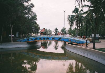 Swimming pool by lake against sky