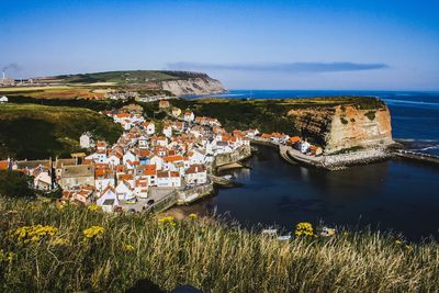 Scenic view of sea by buildings against sky