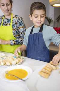 Mother and son making croquettes in the kitchen