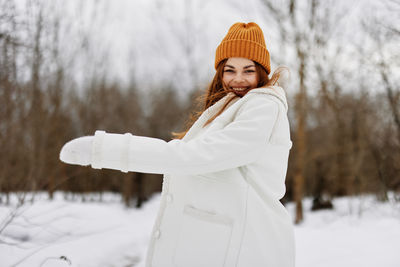 Portrait of young woman standing in snow