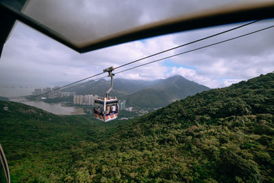 Overhead cable car over mountains against sky