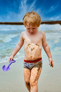 Full length of shirtless boy on beach