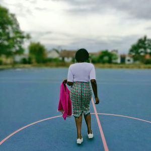 Rear view of woman standing on game court