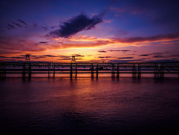 Pier over sea against sky during sunset