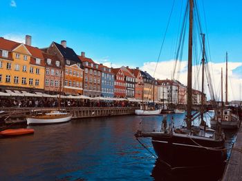 Boats moored at harbor against buildings in city