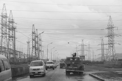 Cars on road in city against sky