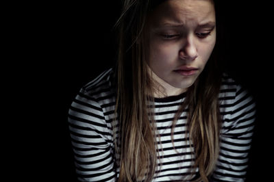 Close-up of girl against black background