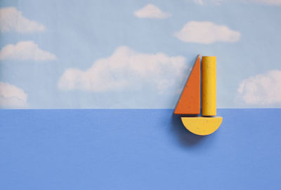 Close-up of yellow flag against blue sky