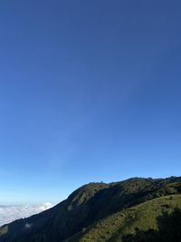 Low angle view of mountain against blue sky