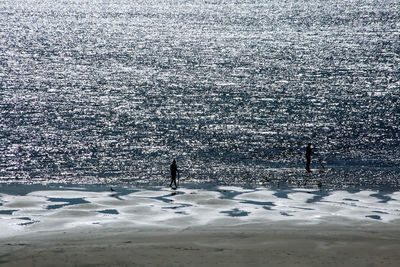 High angle view of silhouette man standing by sea