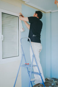 Rear view of man standing against wall