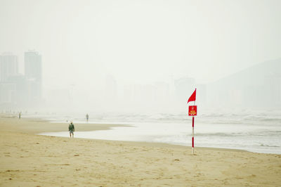 Lifeguard hut on beach against sky in city