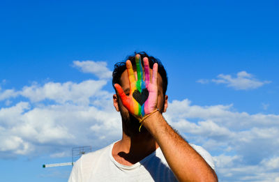 Low angle view of man hand against sky