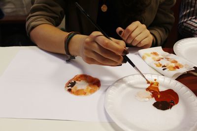 Midsection of woman painting on paper