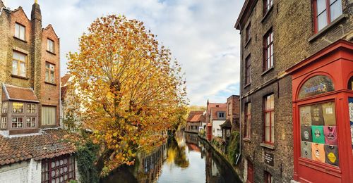 Canal amidst buildings against sky