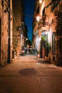 Street amidst buildings in city at night