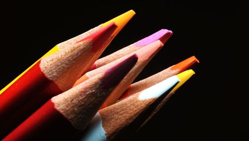 Close-up of multi colored pencils against black background