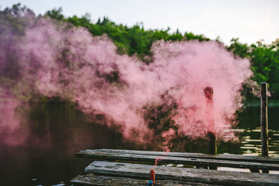 Close-up of pink smoke against lake